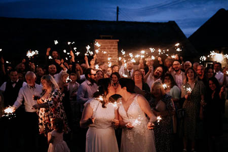 Fiona and Chernay kissing with sparklers waving