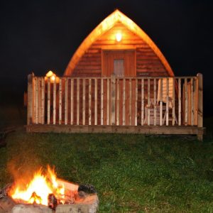 Glamping hut exterior illuminated at night