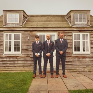 Gents standing outside a cottage