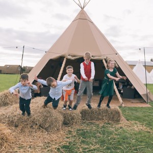 Jonathan Stockton Photography - Kids playing outside a wigwam